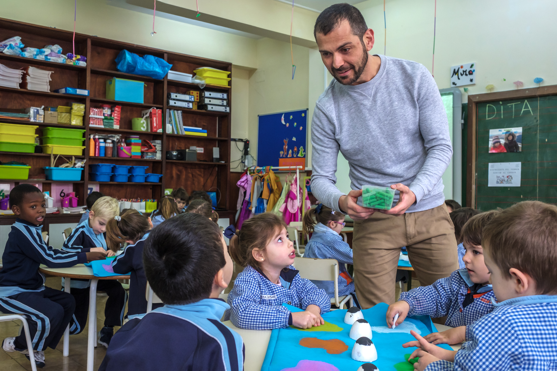 Profesor mostrando una actividad a los más pequeños